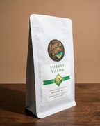 White coffee bag with 'Fabled Roast' label on a wooden surface and brown background